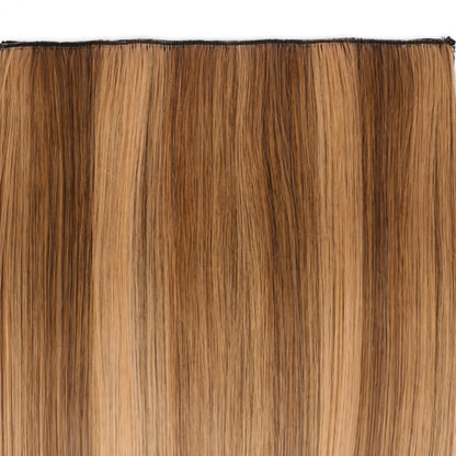 Close-up view of Stranded Hair Group clip-in extension in warm brown and golden Honey Blush colour