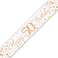 A white 50th birthday banner or sash printed with 'Happy 50th Birthday!' in metallic rose gold script, decorated with rose gold and gold confetti dots and dashed lines, shown diagonally on a white background.
