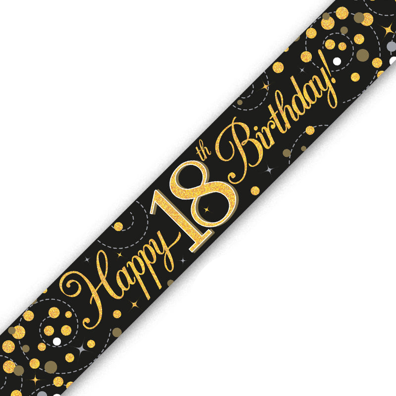 A black 18th birthday banner or ribbon printed with 'Happy 18th Birthday!' in gold script and gold confetti patterns, shown diagonally on a white background.