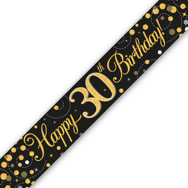 A black 30th birthday banner or sash printed with 'Happy 30th Birthday!' in gold script and decorated with gold and white confetti dots, shown diagonally on a white background.