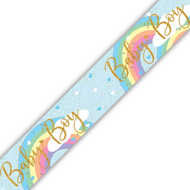 A diagonal strip of decorative paper or tape featuring a pastel rainbow, white clouds, small hearts, gold glitter speckles, and the words 'Baby Boy' in large gold cursive lettering on a white background.