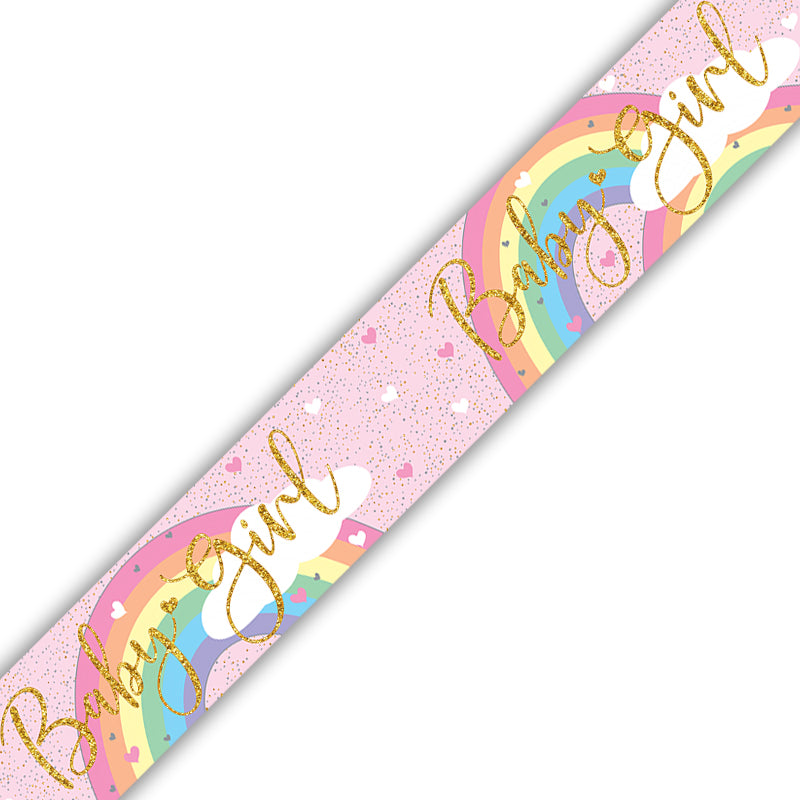 A close-up of a decorative strip featuring a pastel rainbow, pink glitter background, small hearts, and the words 'Baby Girl' in large gold script.