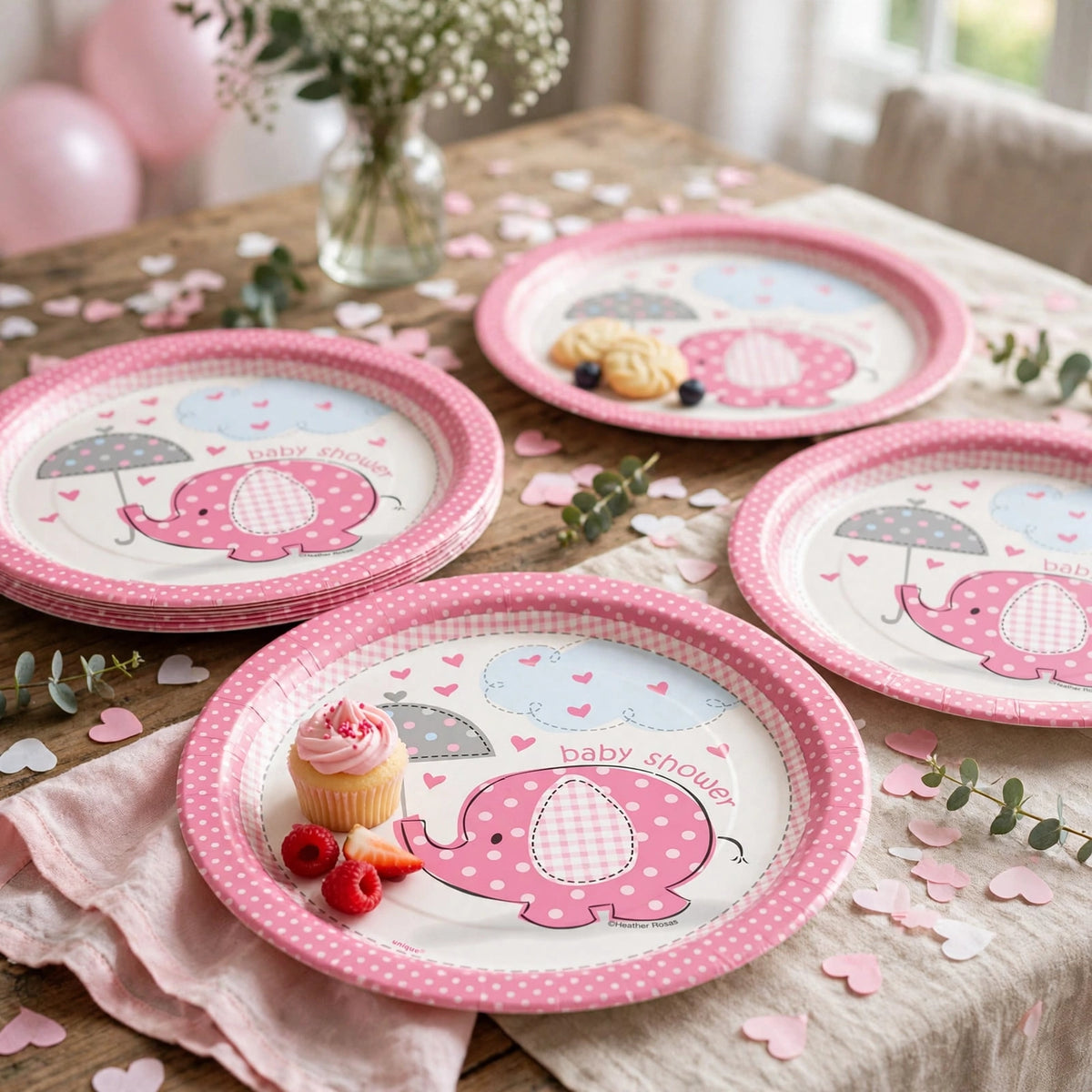 Pink and white Umbrellaphants baby shower plates displayed on a decorated baby shower table