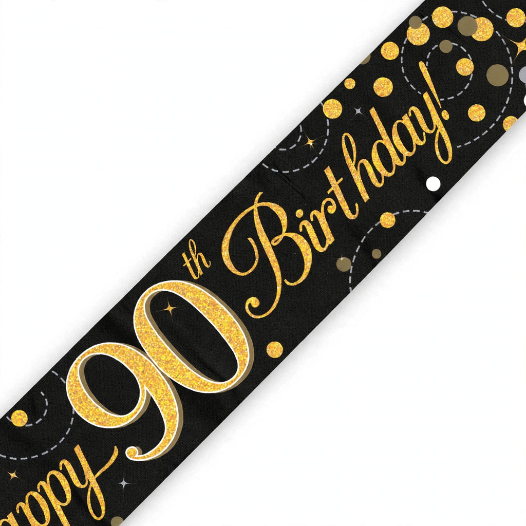 Close-up of black and gold 90th birthday banner with sparkling fizz detailing