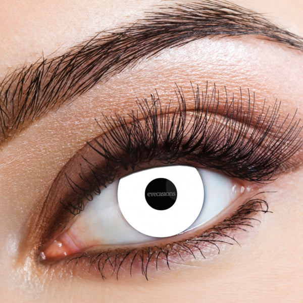 Extreme close-up of a human eye wearing a white contact lens with a black pupil center and the brand name 'eyecamo' visible, with brown eyeshadow and mascara on the surrounding eye area.