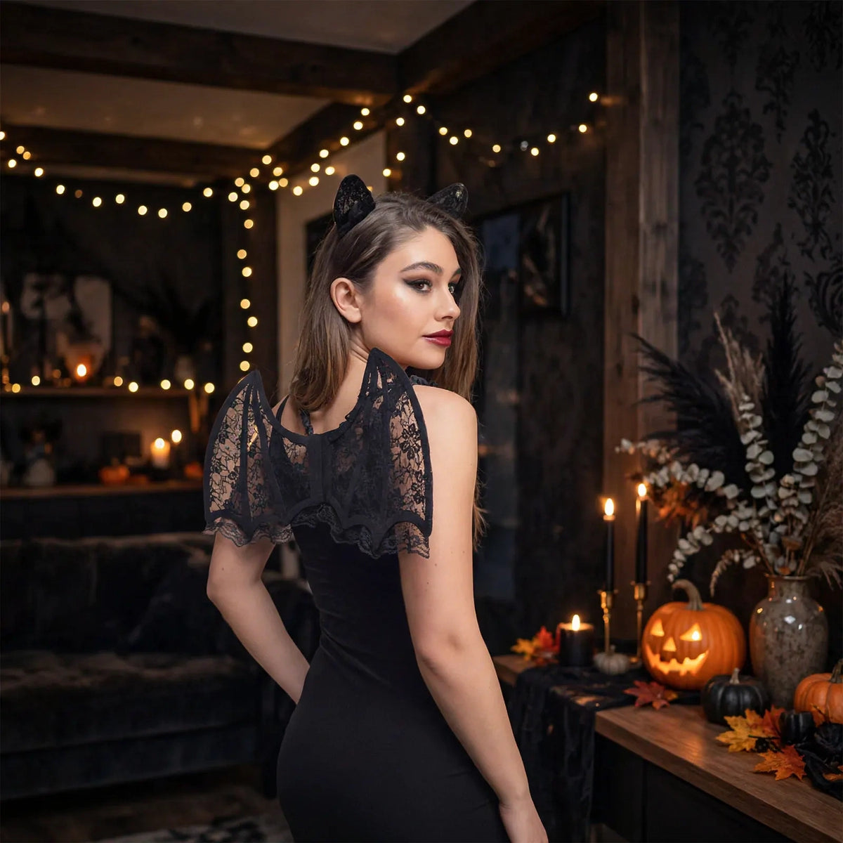 Person wearing adults black lace bat wings cape and bat ear headband at a costume event