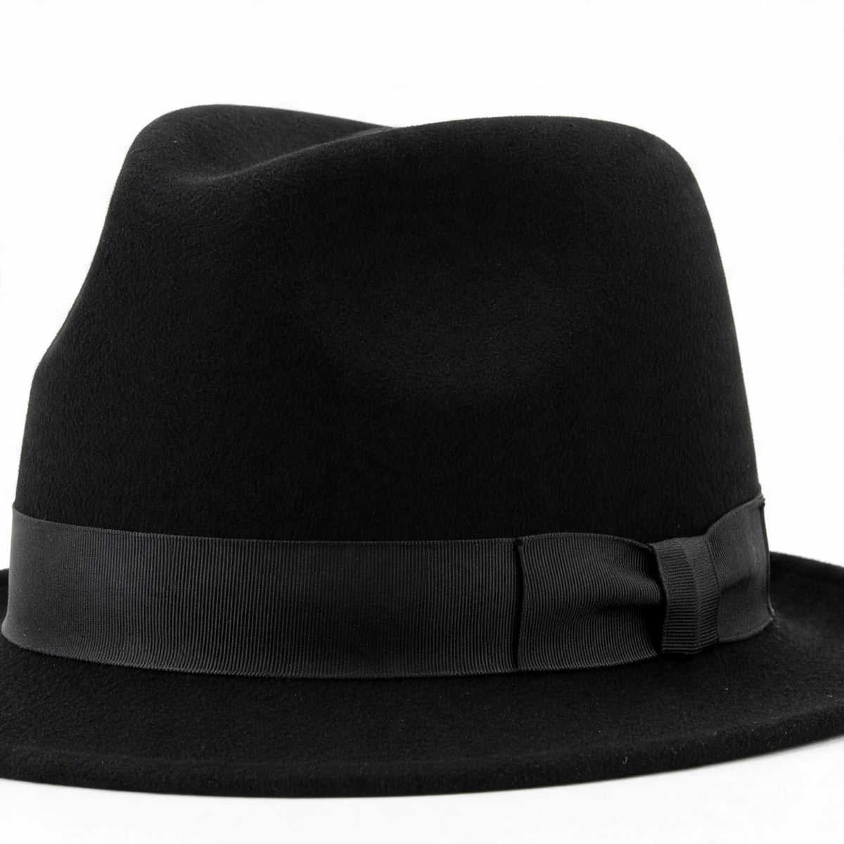 Close-up view of adults black trilby fedora style hat showing pinched crown and short brim