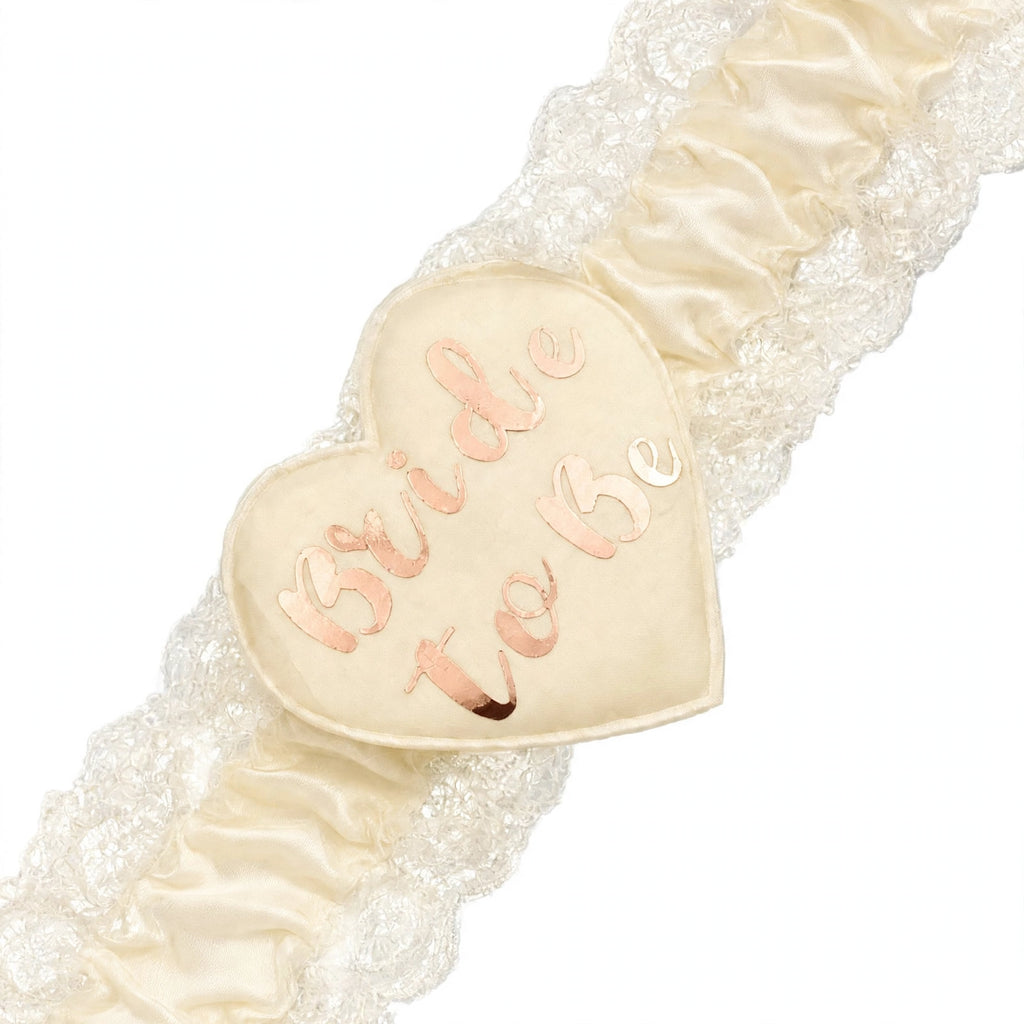 Close-up of heart-shaped Bride To Be centre on cream and gold garter
