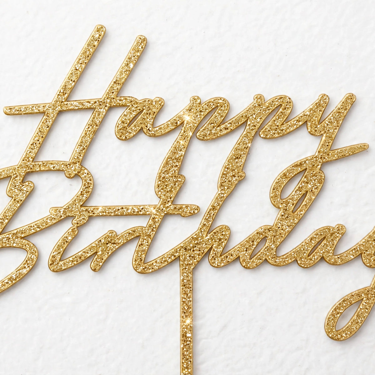 Close-up view of gold glitter Happy Birthday Cake Topper showing decorative script