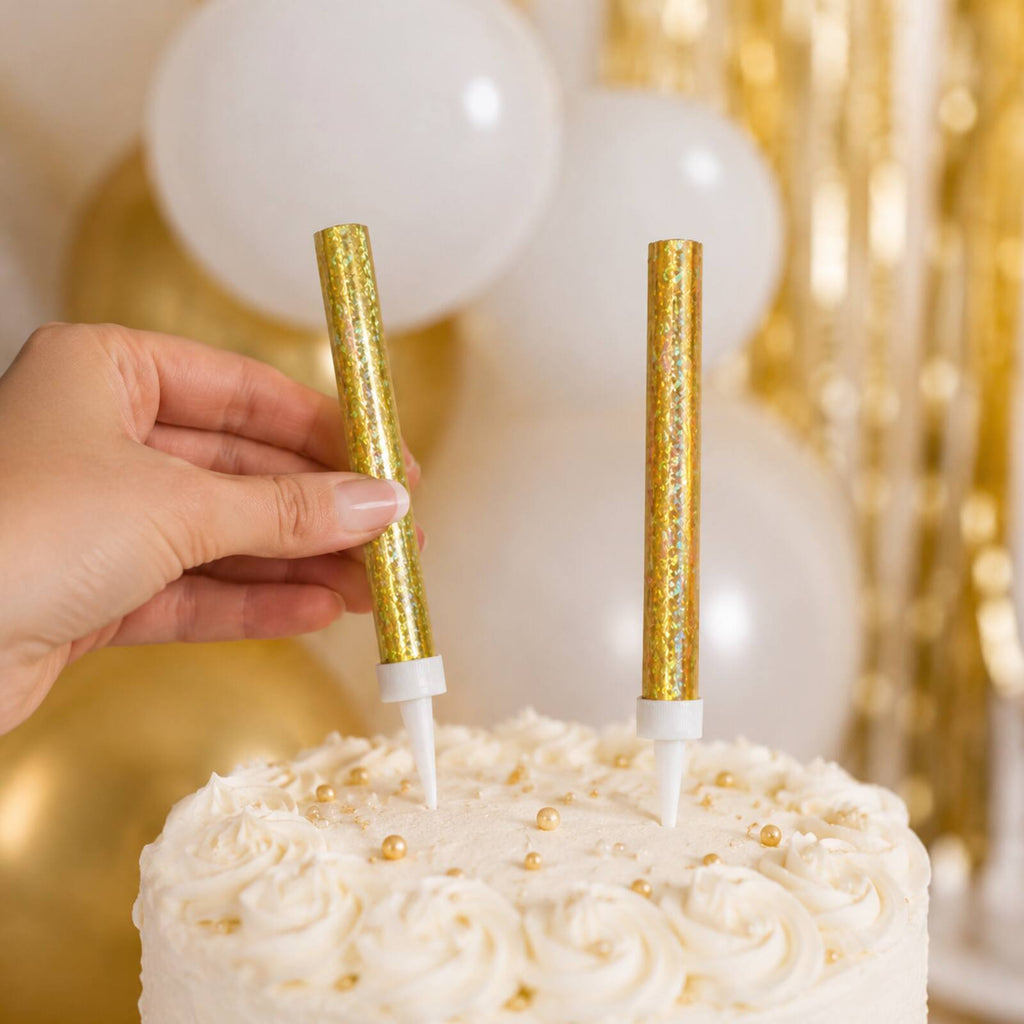 Adult safely placing two unlit gold prismatic ice fountain decorations into a cake