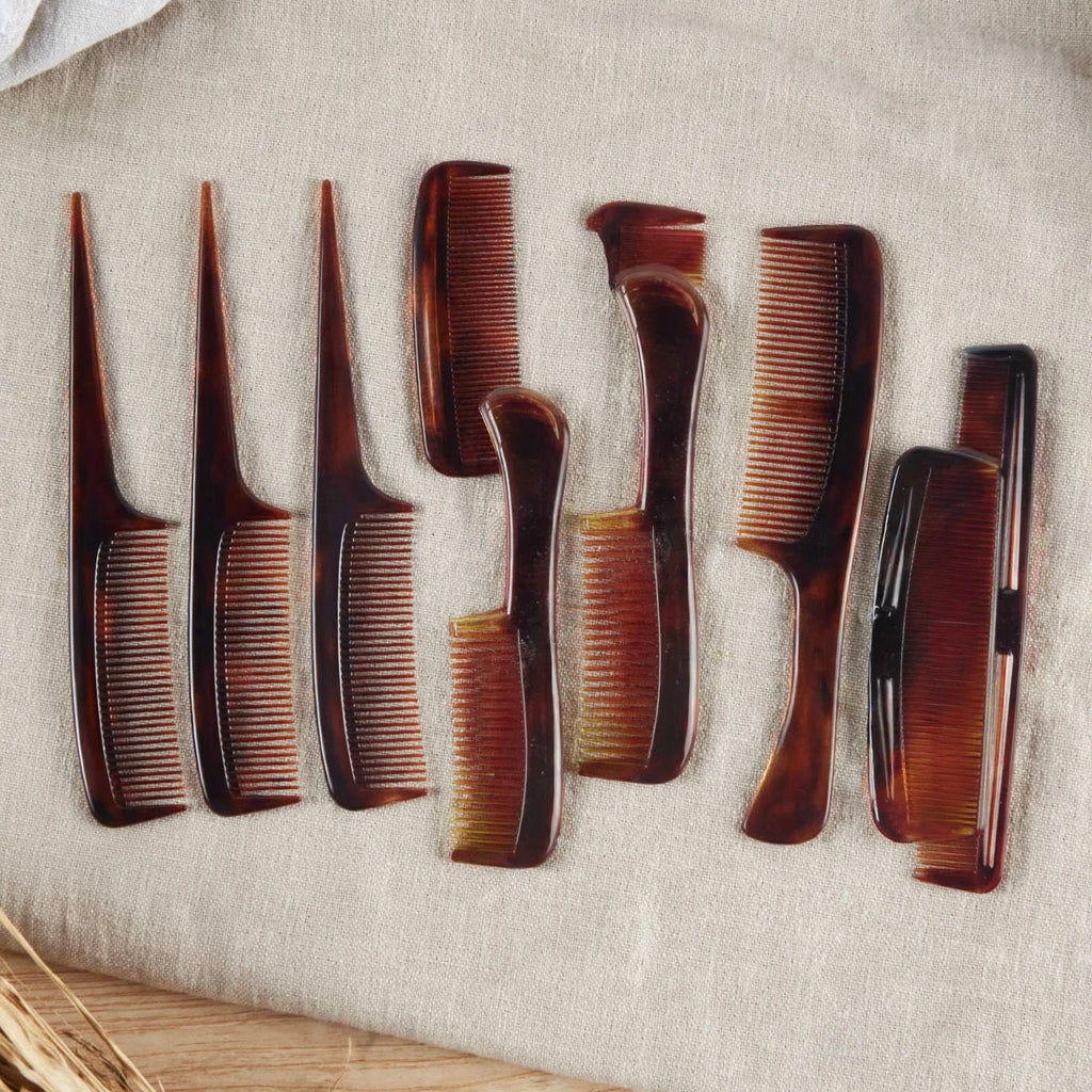 Brown tortoiseshell style hair comb being used for styling hair