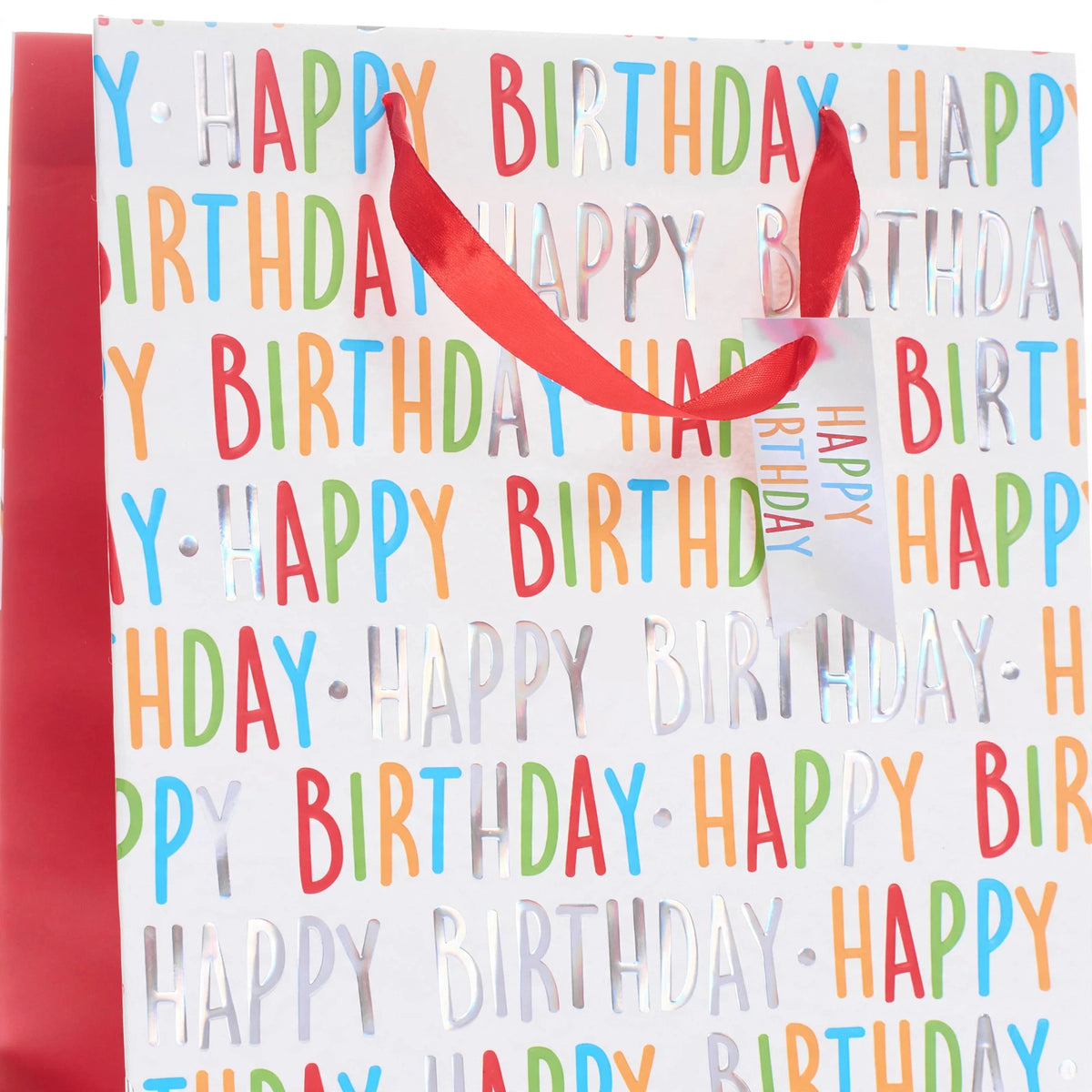 Close-up view of multi-coloured Happy Birthday print and ribbon carry handle on medium gift bag