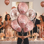 Stylish woman holding rose gold happy birthday balloons at elegant celebration with cake and champagne