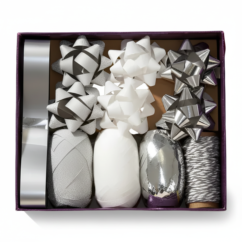 Silver bow and ribbon gift wrapping set in open plum box, studio white background