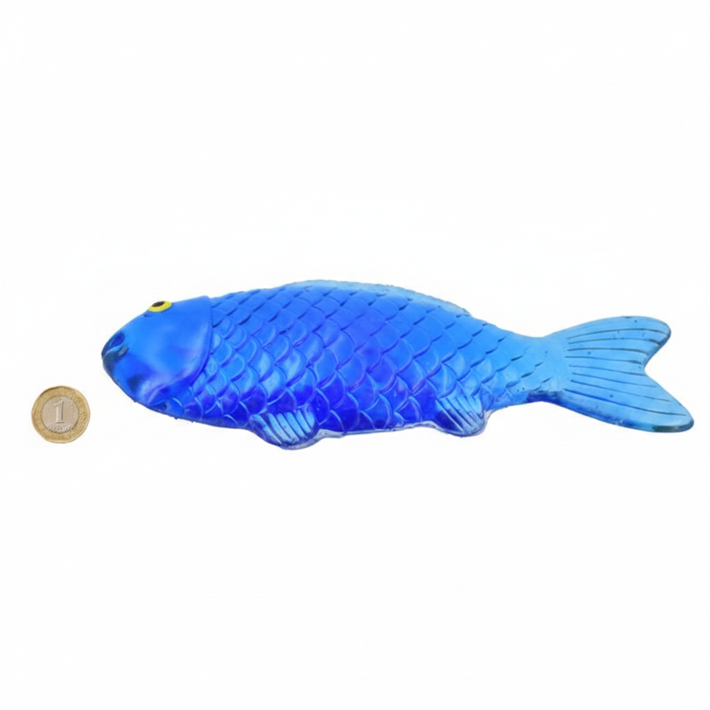 Sticky Fish Squishy Squeeze blue toy beside a £1 coin showing product size on white background