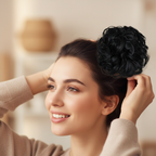 Woman styling her hair with a jet black curly messy hair bun clip-in hairpiece, candid natural moment with bokeh background