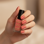 Barry M Velvet Matte Nail Paint Burning Sand 243 – woman applying coral nail polish, candid close-up with creamy bokeh background