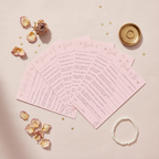 Elegant flat lay of all 8 Team Bride hen party advice cards fanned out on blush linen with rose petals and gold confetti