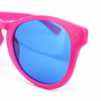 Close-up macro detail of hot pink giant clown glasses frame and mirrored blue lens