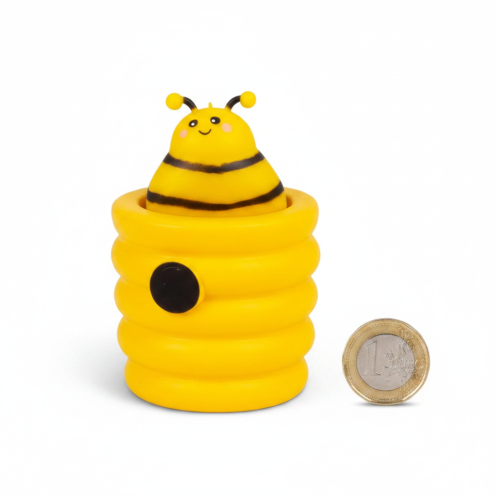 Squishy Pop Up Beehive yellow toy placed beside a £1 coin on white background to show compact pocket size