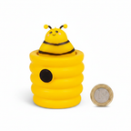 Squishy Pop Up Beehive yellow toy placed beside a £1 coin on white background to show compact pocket size