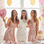 Group of women celebrating at a hen party with bride sash and pink decorations