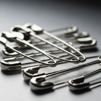 Extreme macro close-up of Tiger Stationery silver nickel-plated safety pins showing smooth metal finish and precision clasp mechanism
