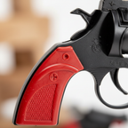 Close-up macro detail of 8-Shot Cap Gun red grip and matte black body texture