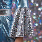 Extreme macro close-up of silver holographic sequin bell sleeve panel on ABBA Waterloo blue disco jumpsuit — texture and shimmer detail