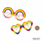 Two pairs of Gay Pride cardboard novelty glasses flat lay beside UK £1 coin on white background showing scale