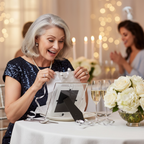 Stylish woman unwrapping a silver Age 60 milestone photo frame gift at a 60th birthday party