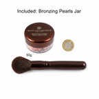 Body Collection Bronzing Pearls 50g flat lay with £1 coin for scale and bronzer brush on white background