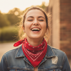Woman wearing red and white paisley bandana as neckerchief, laughing candidly in denim jacket