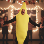 Man wearing the Barmy Banana Adults Fancy Dress Costume mid-laugh at a party, costume sharp against creamy bokeh background