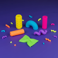 All six Scrunchems Stretchy Squeezy Pasta Shapes arranged on dark background with neon pasta confetti scattered around