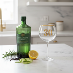 Art Deco 30th Birthday Gin Glass on marble countertop with premium gin bottle and botanicals in natural window light