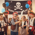 Children enjoying pirate-themed birthday party wearing costume accessories including eyepatch and sword