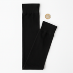 Black thigh high stockings flat lay on white background with UK £1 coin for scale reference