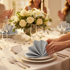 Silver luncheon napkins elegantly set on a celebration dinner party table with champagne glasses