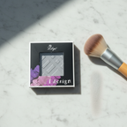 Lilyz Eyeshadow Mono Misty Silver on marble surface with makeup brush and shimmer swatch
