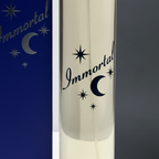 Extreme macro close-up of Immortal EDP clear glass bottle texture, chrome silver cap and dark navy moon and stars branding
