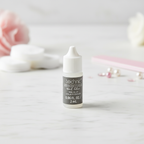 Technic Essentials clear false nail glue 2ml tube on white marble with pink nail accessories