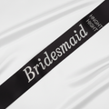 Black satin and diamante bridesmaid sash displayed on white background showing luxurious satin finish and sparkling crystal detailing