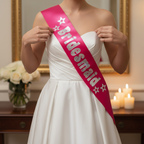 Close-up of Hot Pink Bridesmaid Sash with Silver Foil Writing being adjusted in elegant bridal suite setting