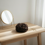 Dark brown curly messy hair bun shade 2 Nigella on a dressing table vanity with natural window light, interior magazine styling