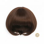 Diva brown bob wig beside a £1 coin on white background showing product size — flat lay