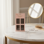 Glamorize Hair Grips blush pink packaging on marble vanity dressing table with mirror and hairbrush, natural window light