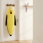 Barmy Banana Adults Fancy Dress Costume hanging on a wooden coat hook in a bright airy hallway with a party hat and confetti nearby