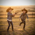 Children playing cowboys with cap gun toy at golden hour - joyful imaginative play