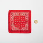 Red and white paisley bandana flat lay on white background with pound coin for scale reference